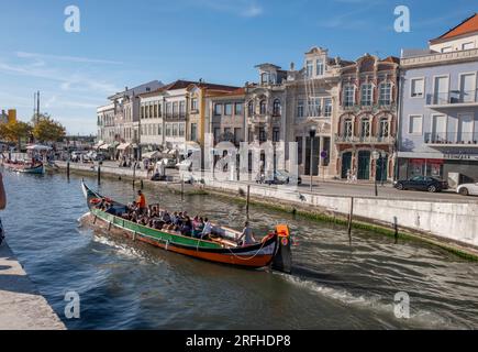 Aveiro, Portogallo, 01.10.2022 - Aveiro canale d'acqua di Ria de Aveiro con (moliceiro) barche tipiche con turisti e il paesaggio urbano sullo sfondo. Foto Stock