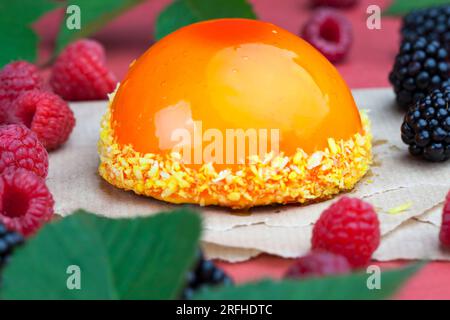 torta all'arancia con ripieno bianco cremoso, marmellata di pesca gialla con lamponi e more Foto Stock