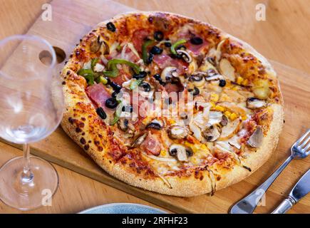 Pizza doppia servita su tavola di legno Foto Stock