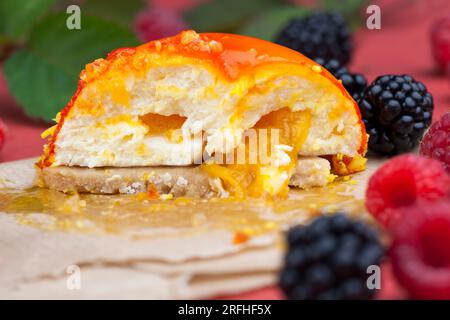 marmellata di pesche gialle con lamponi e more, torta all'arancia con ripieno bianco cremoso Foto Stock