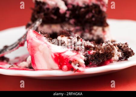 torta a più strati composta da torte con crema di formaggio cottage e sapore di castagne, torta al cioccolato con crema ricoperta di marmellata di fragole rosse Foto Stock