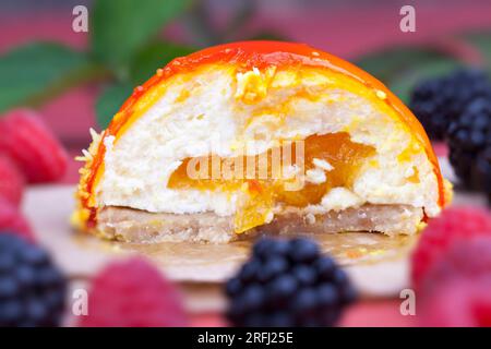 torta all'arancia con ripieno bianco cremoso, marmellata di pesca gialla con lamponi e more Foto Stock