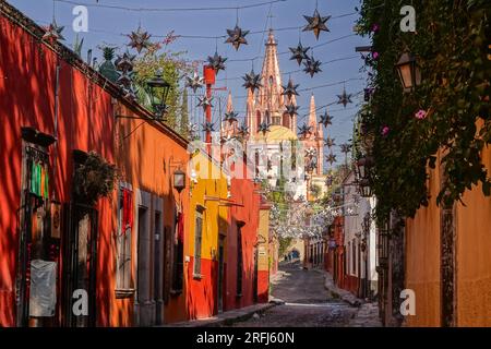 Stelle messicane di latta si stagliavano lungo la Calle Aldama acciottolata con il campanile rosa della Parroquia de San Miguel Arcangel che svetta sopra nel centro storico della città di San Miguel de Allende, Messico. Foto Stock