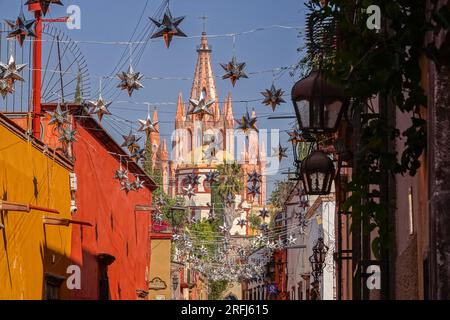 Stelle messicane di latta si stagliavano lungo la Calle Aldama acciottolata con il campanile rosa della Parroquia de San Miguel Arcangel che svetta sopra nel centro storico della città di San Miguel de Allende, Messico. Foto Stock