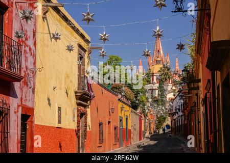 Stelle messicane di latta si stagliavano lungo la Calle Aldama acciottolata con il campanile rosa della Parroquia de San Miguel Arcangel che svetta sopra nel centro storico della città di San Miguel de Allende, Messico. Foto Stock