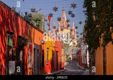 Stelle messicane di latta si stagliavano lungo la Calle Aldama acciottolata con il campanile rosa della Parroquia de San Miguel Arcangel che svetta sopra nel centro storico della città di San Miguel de Allende, Messico. Foto Stock