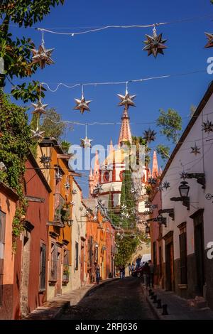 Stelle messicane di latta si stagliavano lungo la Calle Aldama acciottolata con il campanile rosa della Parroquia de San Miguel Arcangel che svetta sopra nel centro storico della città di San Miguel de Allende, Messico. Foto Stock