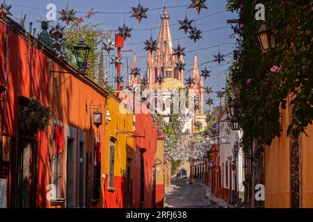 Stelle messicane di latta si stagliavano lungo la Calle Aldama acciottolata con il campanile rosa della Parroquia de San Miguel Arcangel che svetta sopra nel centro storico della città di San Miguel de Allende, Messico. Foto Stock