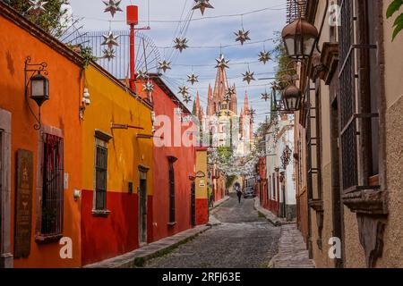 Stelle messicane di latta si stagliavano lungo la Calle Aldama acciottolata con il campanile rosa della Parroquia de San Miguel Arcangel che svetta sopra nel centro storico della città di San Miguel de Allende, Messico. Foto Stock