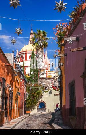 Stelle messicane di latta si stagliavano lungo la Calle Aldama acciottolata con il campanile rosa della Parroquia de San Miguel Arcangel che svetta sopra nel centro storico della città di San Miguel de Allende, Messico. Foto Stock