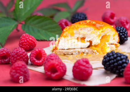 marmellata di pesche gialle con lamponi e more, una torta all'arancia con ripieno bianco cremoso Foto Stock