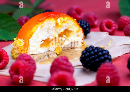 marmellata di pesche gialle con lamponi e more, torta all'arancia con ripieno bianco cremoso Foto Stock