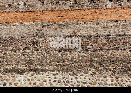 mura combinate di un antico castello, parte delle mura di un castello medievale fatto di pietre, ciottoli e mattoni rossi Foto Stock