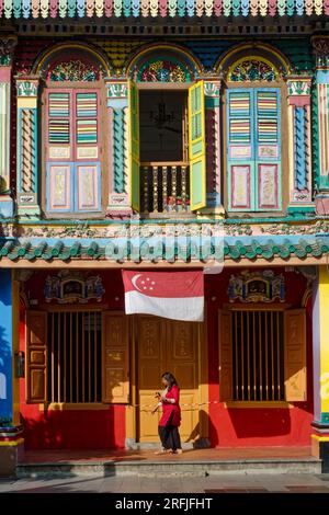 Una donna indiana di etnia cammina davanti alla Casa multicolore di Tan Teng Niah, un'antica villa di mercanti cinesi a Little India, Singapore Foto Stock