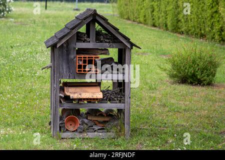 Hotel di api e insetti realizzato con materiali diversi per offrire un rifugio per molte specie nell'ambiente del parco cittadino Foto Stock