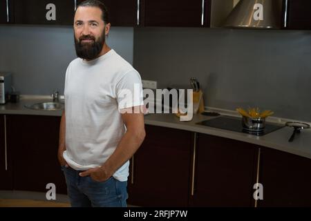 Bell'uomo si trova nella zona cucina della camera d'albergo Foto Stock