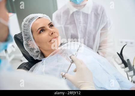 Il paziente calmo si trova su una sedia dentale Foto Stock