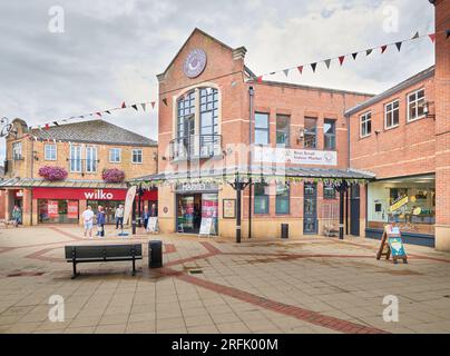 Piccolo mercato al coperto e altri negozi nella zona pedonale dello shopping di St Mary a Market Harborough, Inghilterra. Foto Stock