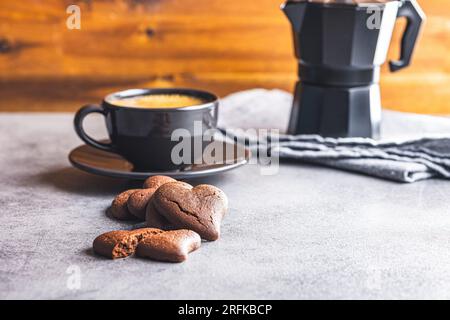 Biscotti a forma di cuore e tazza di caffè sul tavolo della cucina. Foto Stock