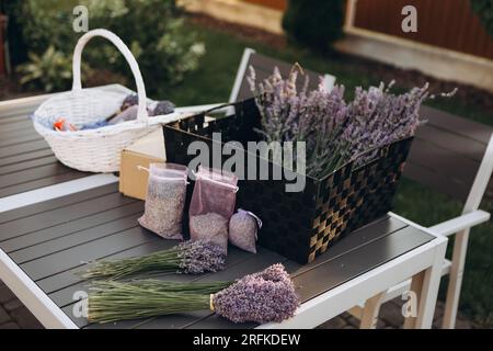 Mazzi di lavanda fresca e sacchetti con lavanda secca sul tavolo Foto Stock