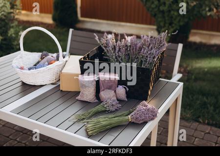 Mazzi di lavanda fresca e sacchetti con lavanda secca sul tavolo Foto Stock