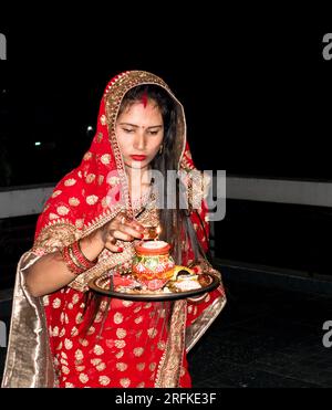 14 ottobre 2022 Uttarakhand, India. Celebrazione culturale: Donna sposata indiana che esegue il rituale Karwachauth pooja in abiti tradizionali. Abbracciare l'indù Foto Stock