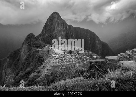 Vista di Macchu Picchu dall'ingresso, sotto un cielo tempestoso Foto Stock