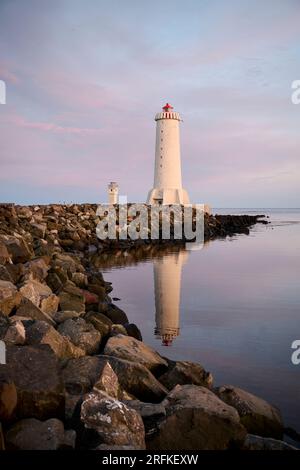 Faro sulla costa del mare al tramonto Foto Stock