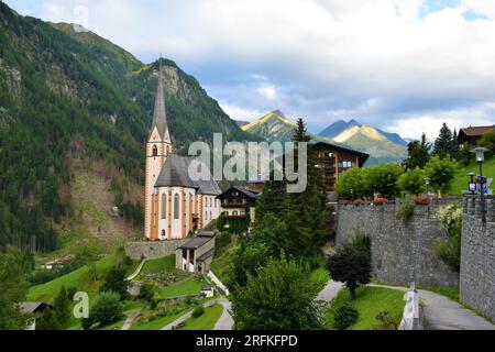 Vista della chiesa di San Vincenzo a Heiligenblut am Großglockner nel quartiere di Spittal an der Drau in Carinzia, Austria. Con il massiccio del Grossglockner ad ho Foto Stock