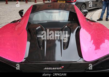 Primo piano del bagagliaio e del lunotto dell'auto sportiva rosa fluorescente McLaren degli anni '570, parcheggiata regolarmente fuori dall'esclusivo Renaissance Hotel. Foto Stock