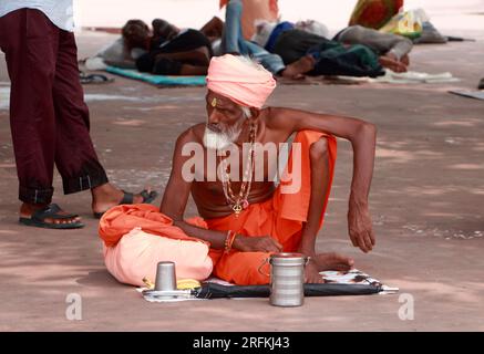 Un monaco seduto al Triveni Ghat a Rishikesh. Foto Stock