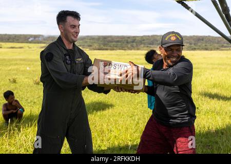 Basco, Filippine. 3 agosto 2023. STATI UNITI Daniel Lauer, a sinistra, passa i rifornimenti di emergenza a un cittadino filippino a sostegno degli sforzi di soccorso in seguito al tifone Egay, 3 agosto 2023, a fuga Island, Filippine. L'uragano di categoria 4 attraversa parte delle Filippine con venti da 140 mph, uccidendo almeno 26 persone e causando danni estesi. Crediti: CPL. Sean Potter/US Army/Alamy Live News Foto Stock