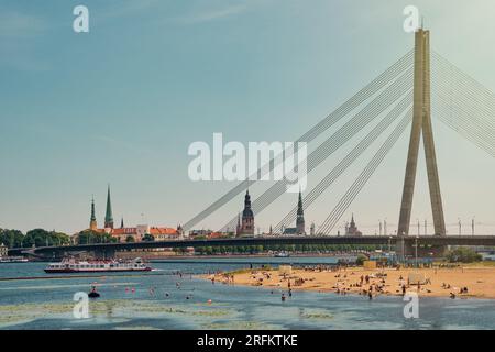 Vista della spiaggia sul fiume Daugava e della città vecchia di riga, del castello di riga e del ponte sul fiume Daugava nella città di riga, Lettonia. Foto Stock