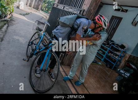 Bogor, Indonesia - 1 agosto 2023: Marito che saluta la moglie e il bambino per andare a lavorare a Bogor, Giava Occidentale. Foto Stock