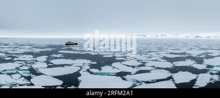 Nave da spedizione che naviga attraverso i ghiacci delle Svalbard Foto Stock