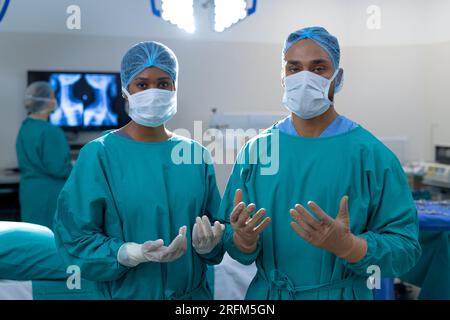 Ritratto di diversi chirurghi che indossano abiti chirurgici in sala operatoria all'ospedale Foto Stock