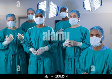 Ritratto di diversi chirurghi che indossano abiti chirurgici in sala operatoria all'ospedale Foto Stock