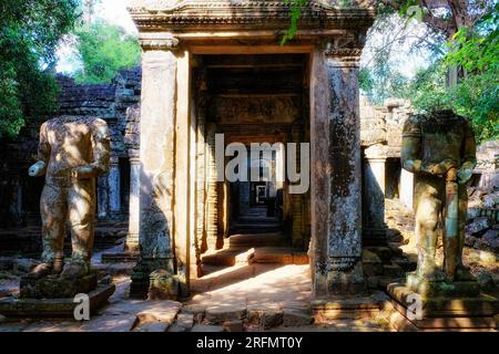 Due antiche sculture danneggiate vicino all'ingresso di un tempio buddista medievale, Preah Khan. Foto Stock