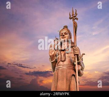 L'enorme statua Shiva Mangal Mahadev è un pezzo d'arte di 33 m nel tempio di Ganga talao sul cielo blu sera tramonto, isola Mauritius. Foto Stock
