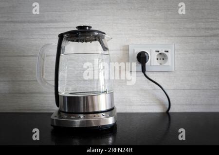 Acqua pura bolle in un bollitore elettrico sul tavolo in cucina Foto Stock