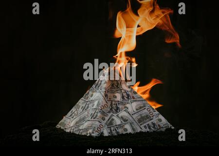 Il concetto di cambio nei mercati finanziari è il crollo del sistema finanziario del capitalismo, il crollo di una piramide finanziaria, i dollari sono burni Foto Stock