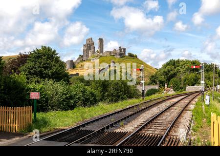 Vista diversa del castello di Corfe sull'isola di Purbeck Dorset. Guardando attraverso la ferrovia Swanage verso il castello sulla collina. Bella giornata estiva. Foto Stock