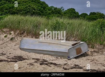 Una piccola barca a remi spiaggiata su una duna di sabbia. A West Yarmouth a Cape Cod, Massachusetts, USA. Foto Stock