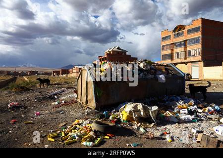 Traboccante di rifiuti e casa in mattoni accanto al Rio Seco nella periferia di El alto, altiplano e monte Huayna Potosí sullo sfondo, Bolivia Foto Stock