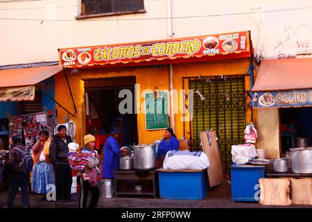 Gente Aymara all'esterno del ristorante locale che vende caldo de cordero / zuppa di agnello e altri piatti tipici boliviani, la Ceja, El alto, Bolivia Foto Stock