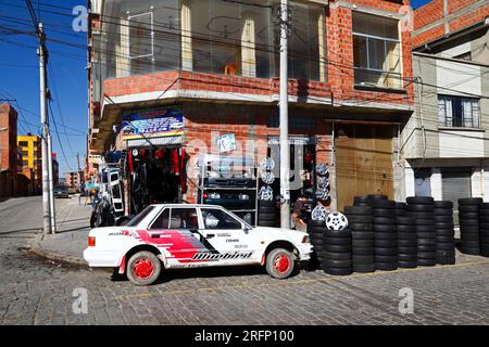 Auto bianca all'esterno del negozio di ricambi che vende pneumatici, ruote e altri accessori per auto, El alto, Bolivia Foto Stock