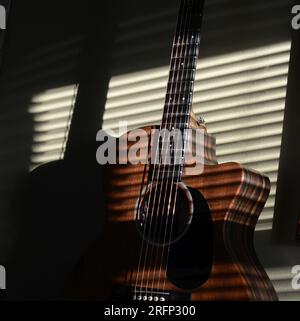 luce del sole attraverso le tende alla chitarra nella luce del pomeriggio Foto Stock