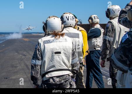 INDIAN OCEAN (4 agosto 2023) i marinai della Royal Australian Navy (RAN) assegnati alla fregata RAN HMAS Perth (FFG 157) osservano come EA-18G Growler, attaccati allo Shadowhawks of Electronic Attack Squadron (VAQ) 141, lanciano fuori dal ponte di volo degli Stati Uniti L'unica portaerei della Marina dispiegata in avanti, la USS Ronald Reagan (CVN 76), durante un tour navale nell'Oceano Indiano, il 4 agosto 2023. Ronald Reagan, l'ammiraglia del Carrier Strike Group 5, fornisce una forza pronta al combattimento che protegge e difende gli Stati Uniti, e sostiene alleanze, partnership e interessi marittimi collettivi nell'Indo-PAC Foto Stock