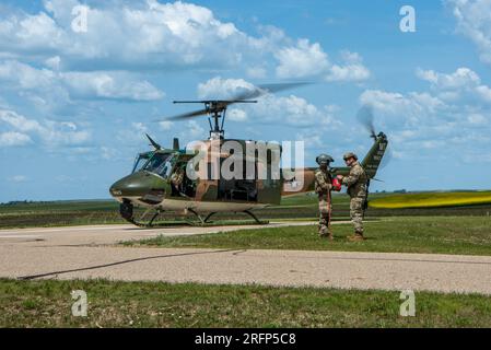 UN U.S. Air Force UH-1N Iroquois assegnato al 54th Helicopter Squadron atterra all'Oscar Missile Alert Facility per recuperare uno spuntino dal personale delle forze di sicurezza in attesa dei passeggeri nel North Dakota, 26 giugno 2023. L'UH-1N ha ricevuto il suo soprannome "Huey" dopo il suono fonetico della sua designazione originale, HU-1. (STATI UNITI Foto dell'aeronautica militare di Airman 1st Class Alexander Nottingham) Foto Stock