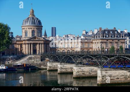 Parigi, Francia - 17 luglio 2017: Persone che attraversano la Senna sul Pont des Arts, di fronte all'Institut de France. Foto Stock